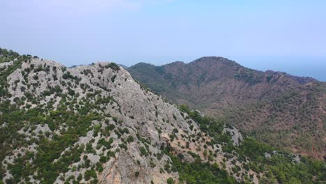 Aerial-scenic-view-over-the-peaks-of-the-rough-Taurus-Mountain-landscape-along-the-coast-of-Antalya-Turkey-on-a-sunny-summer-day