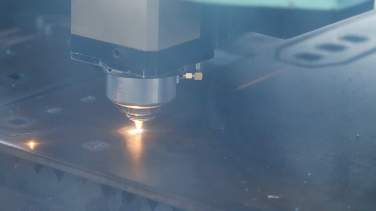 Taglio laser di lamiera con scintille. Attrezzatura industriale in stabilimento.