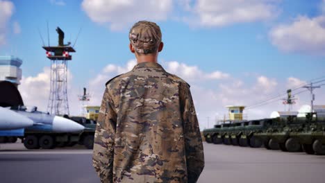 vista trasera de un soldado asiático mirando a su alrededor mientras está de pie en el campamento militar