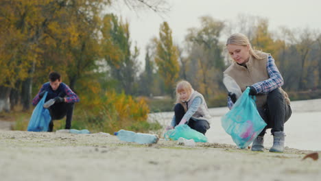 the family collects plastic trash on the lake clean environment concept