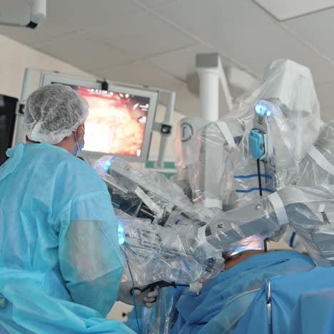 innovative equipment over the patient lying on operating table. surgeon sitting with his back to the camera applies the instrument and looks at the screen