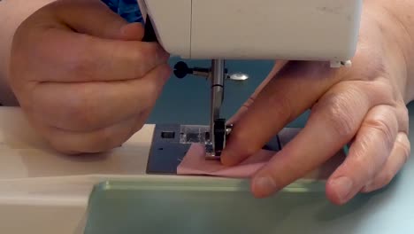 a woman changes the presser foot on a sewing machine