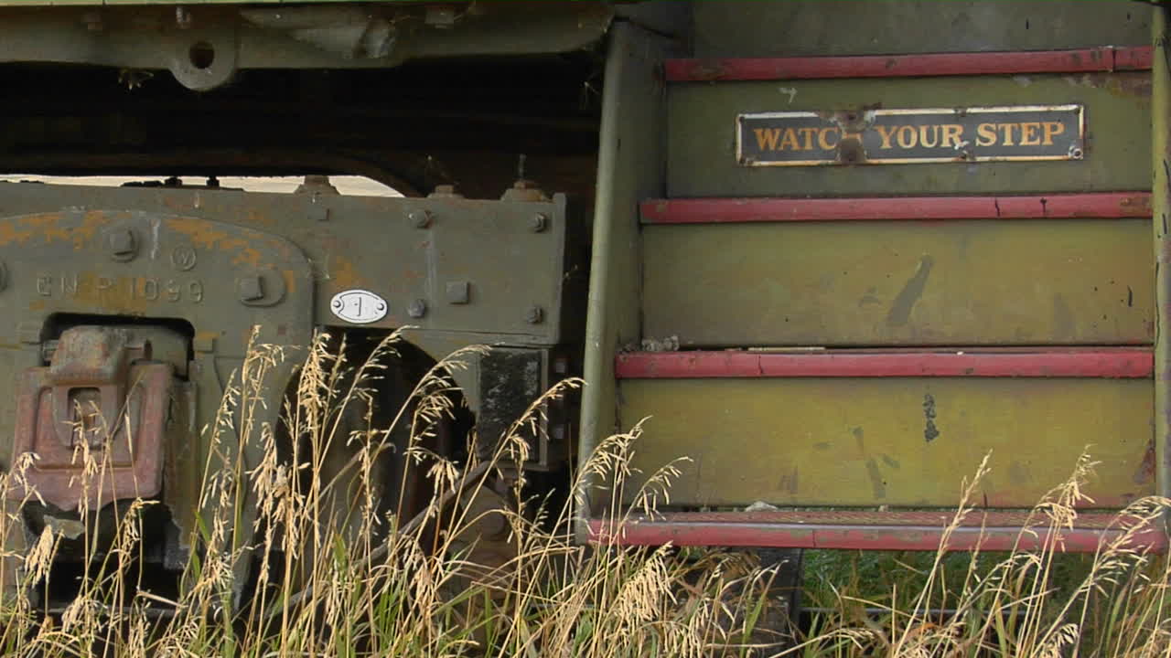 발걸음 조심하라는 표지판이 있는 버려진 철도 차량으로 이어지는 계단