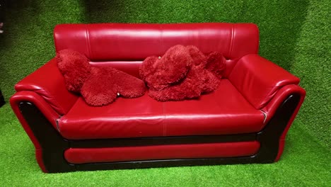 red love seat on artificial turf