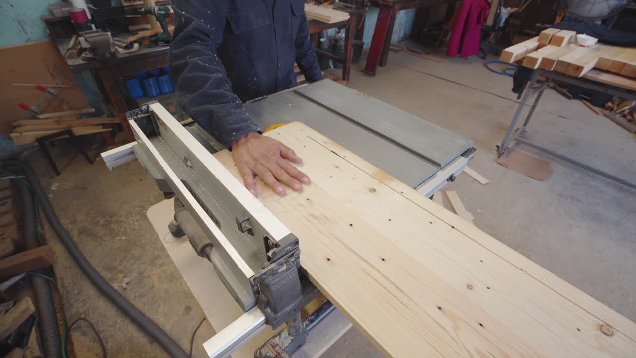 trabajador de la madera que corta tablas de madera reutilizadas en una sierra de mesa