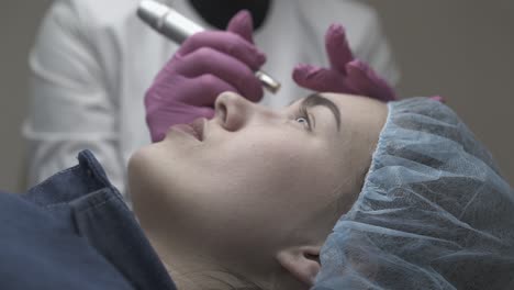 cosmetologist-applies-permanent-eyebrow-make-up-closeup