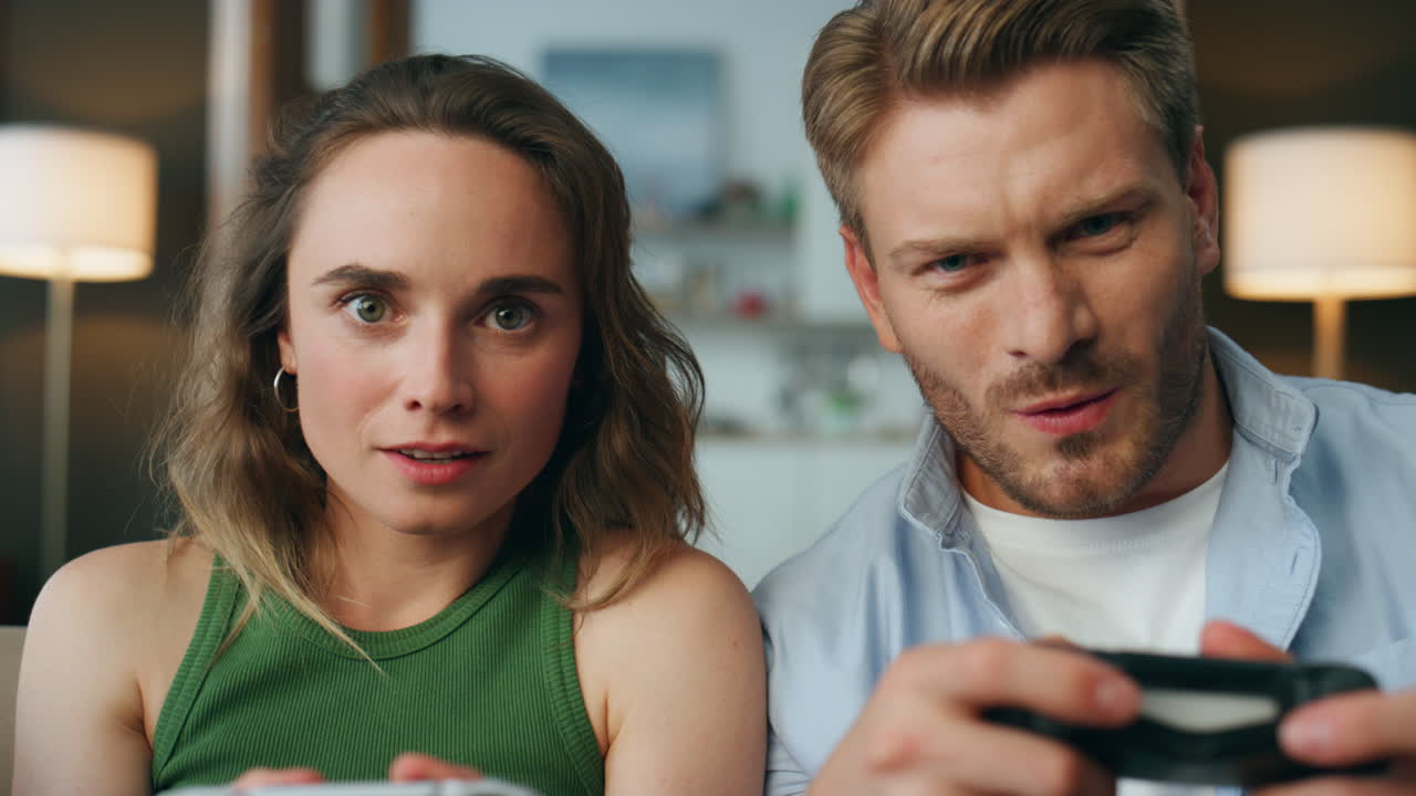 재미있는 파트너는 게임에서 승리합니다. joypads를 들고 실내 pov. 감정적 인 게이머가 놀고 있습니다.