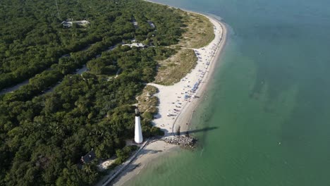 cape florida lighthouse and beach, aerial descend dolly tilt up to golden sandy stretch and city skyline