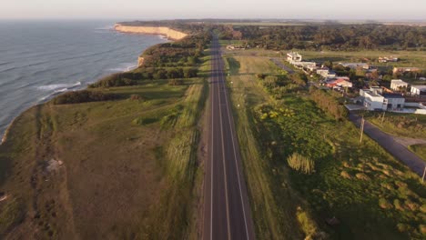 motorcycle driving along deserted and rural road near acantilados cliffs at sunrise, mar del plata in argentine