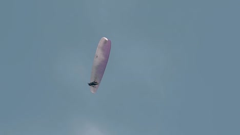 El-Turista-Disfruta-Del-Parapente-Bajo-Un-Cielo-Azul-Claro-En-Cámara-Lenta.