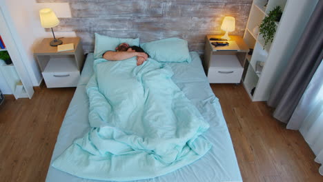 vista superior de una pareja joven durmiendo abrazada