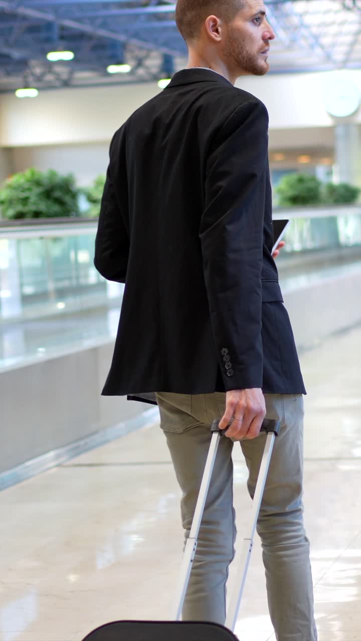 Hombre con maleta caminando en la terminal del aeropuerto