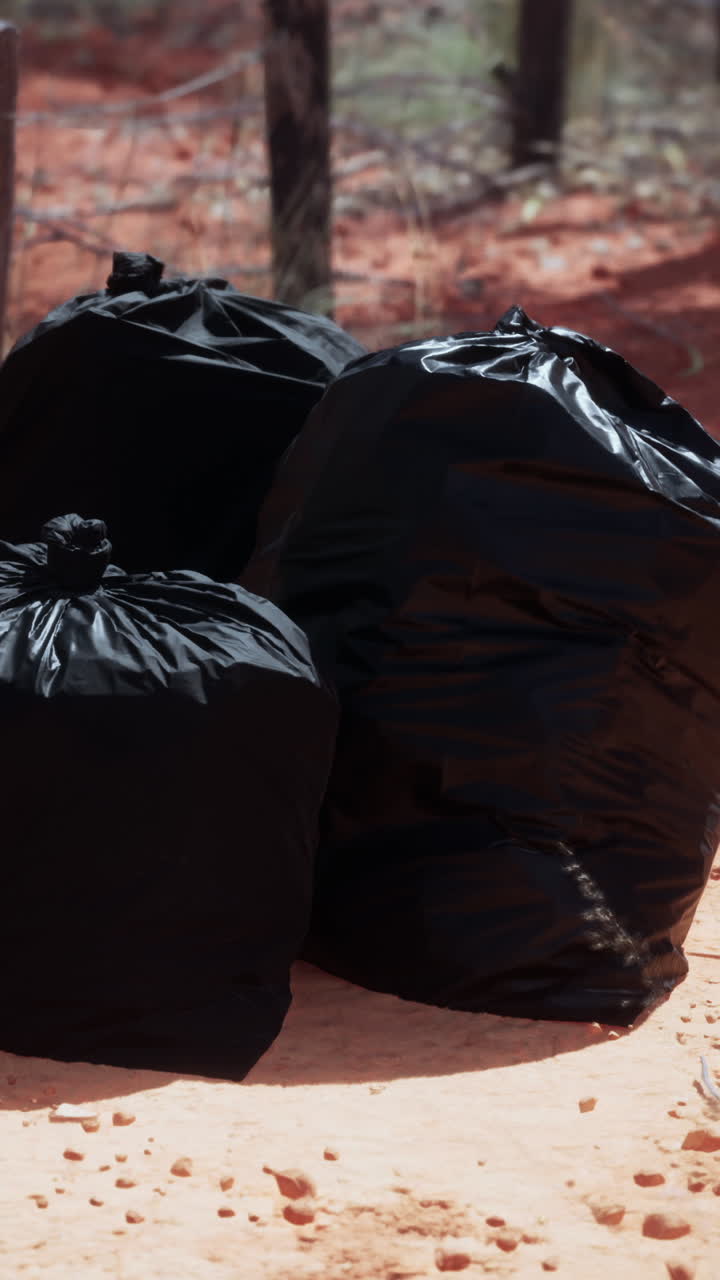 tres bolsas de basura negras en el suelo
