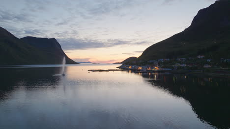 cinematic aerial footage of the sunset and the town torsken in the background, norway, europe