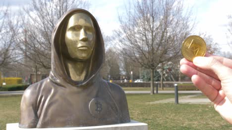 token etherum junto a la estatua de satoshi nakamoto