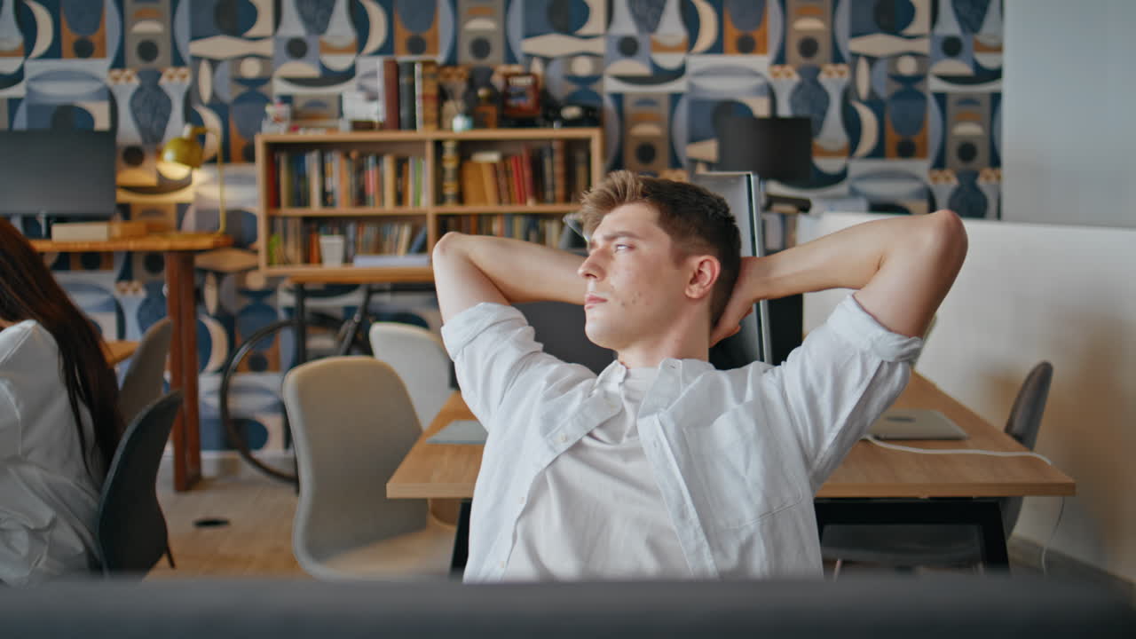 Overworked businessman finishing work in coworking closeup. Manager stretching