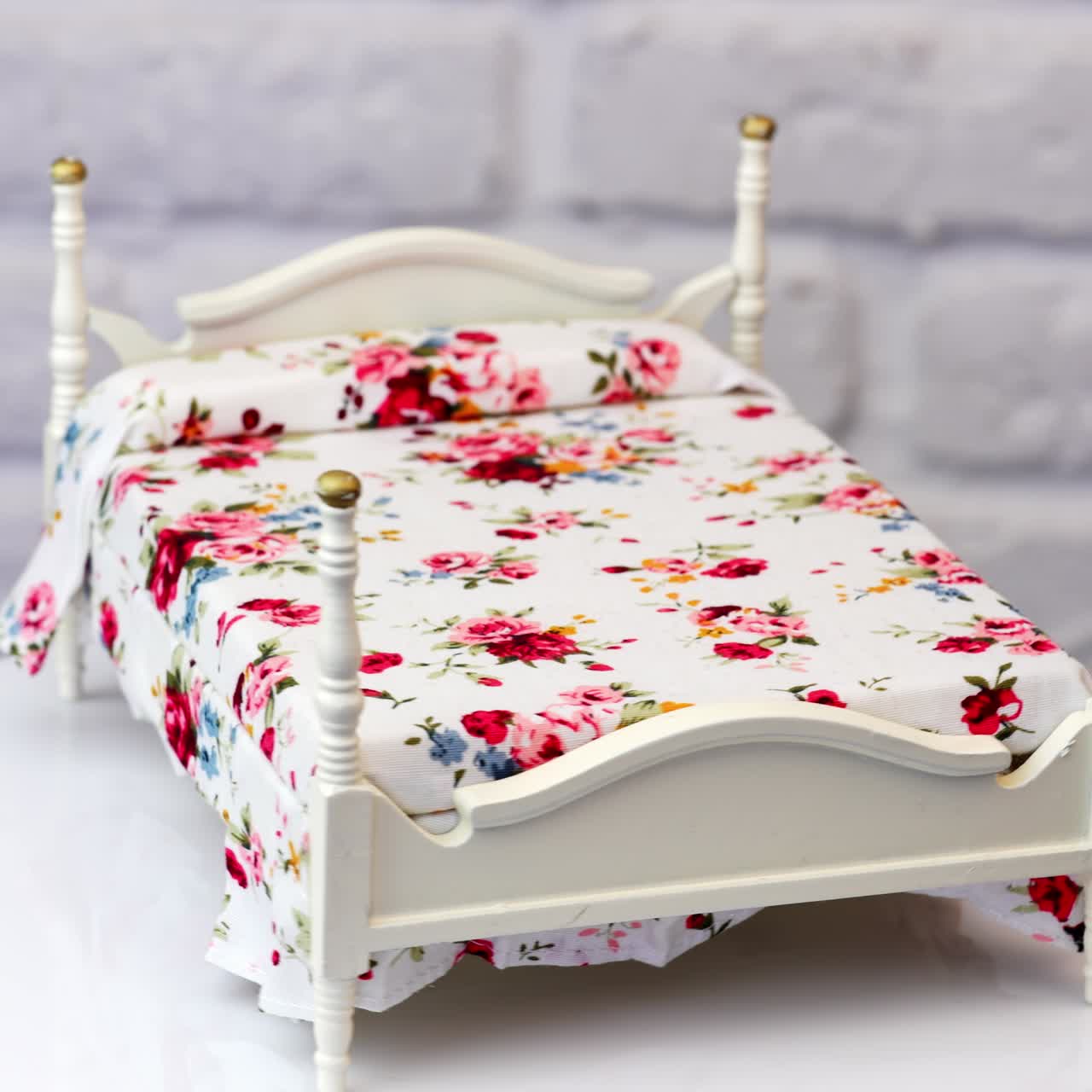 Lovely white bed with beautiful colorful bedding on. Spinning piece of furniture at white background. Close up