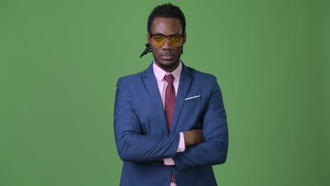 young handsome african businessman with dreadlocks against green background