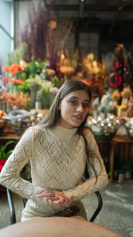 mujer sentada en un café con flores