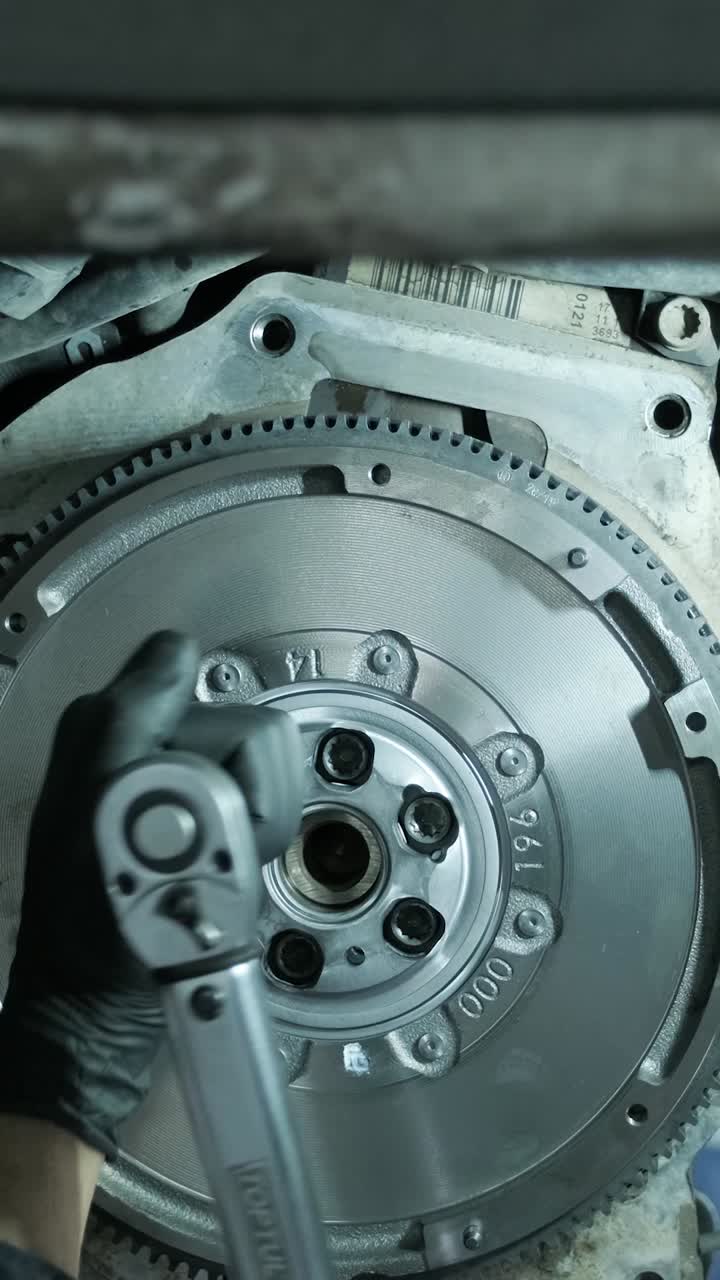 Mechanic Tightening Bolts on Car Flywheel with Torque Wrench