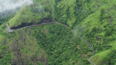 beautiful landscape view at vagamon idukki kerala, aerial view of road in beautiful green forest and low clouds,beautiful view of fast rolling clouds drifting over mountains and hills