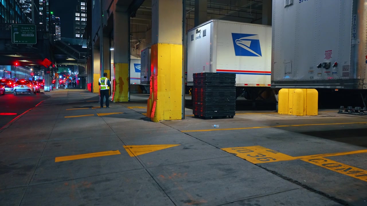 New York, USA, 1 maggio 2026: Lavoratore USPS al molo di carico notturno per camion a Midtown Manhattan. Scena del molo esterno di notte, Midtown Manhattan vicino al Lincoln Tunnel