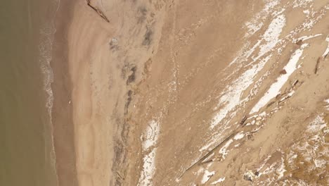 una vista de arriba hacia abajo directamente sobre la playa vacía de coney island creek en un día de invierno