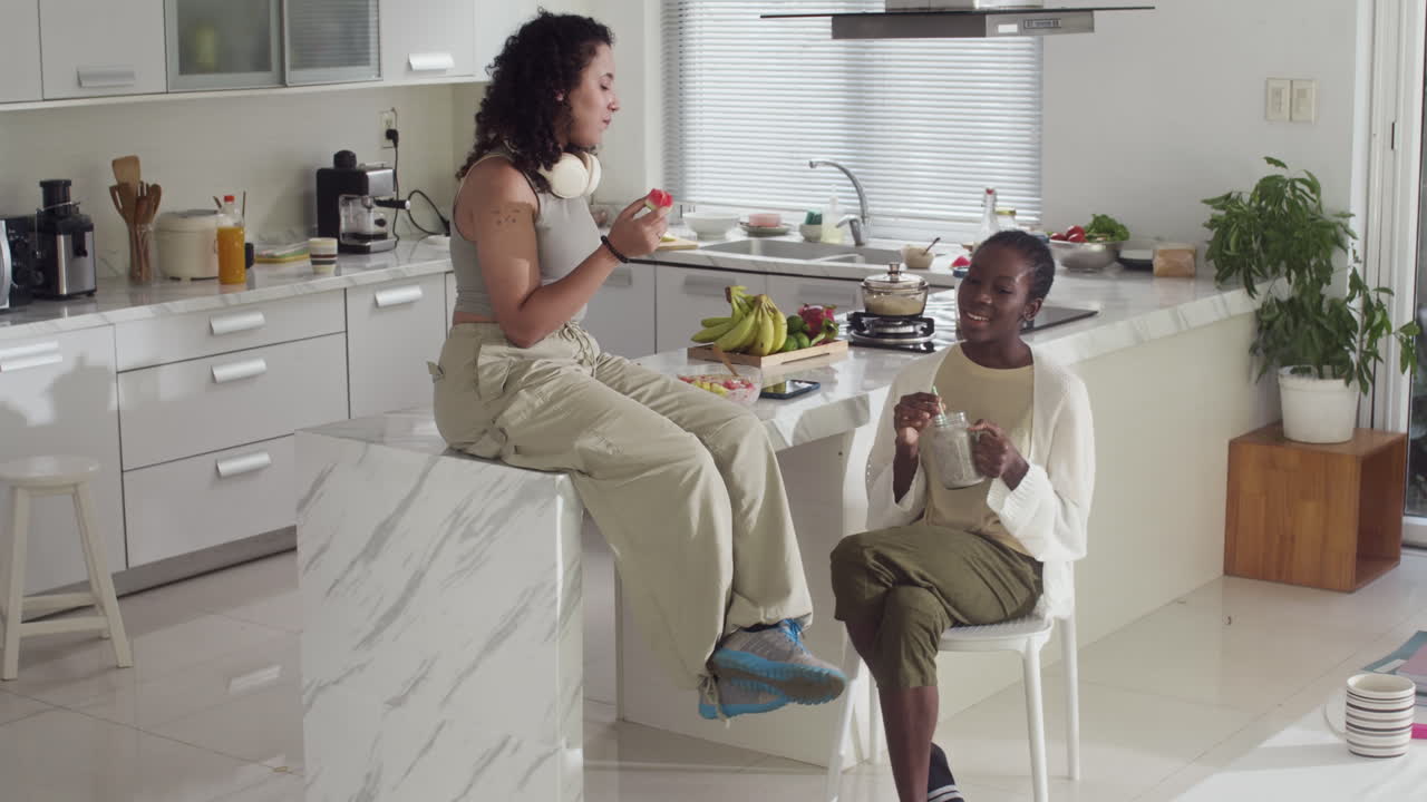 Diverse Women Eating Snacks and Talking at Home