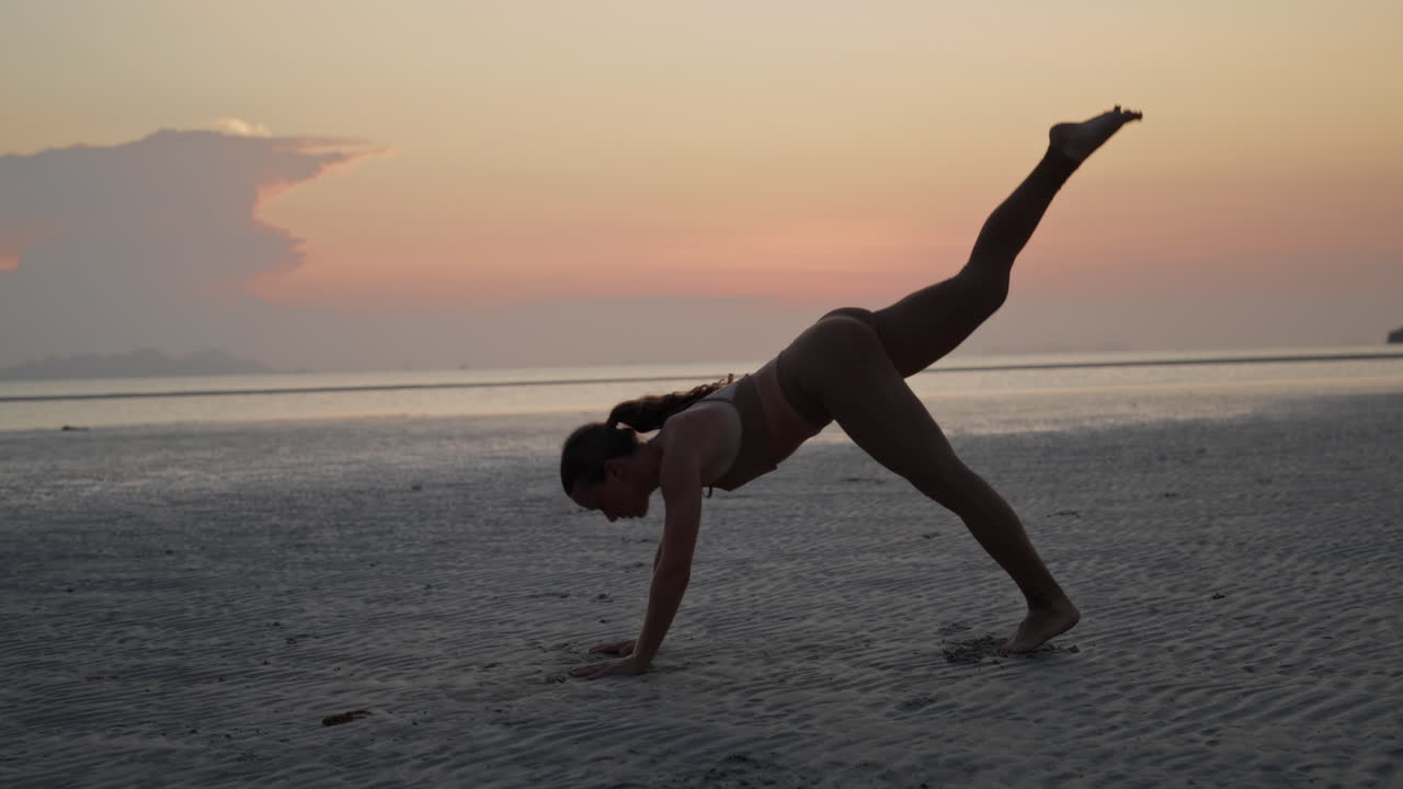 Silhouette einer Frau beim Yoga am Strand bei Sonnenuntergang