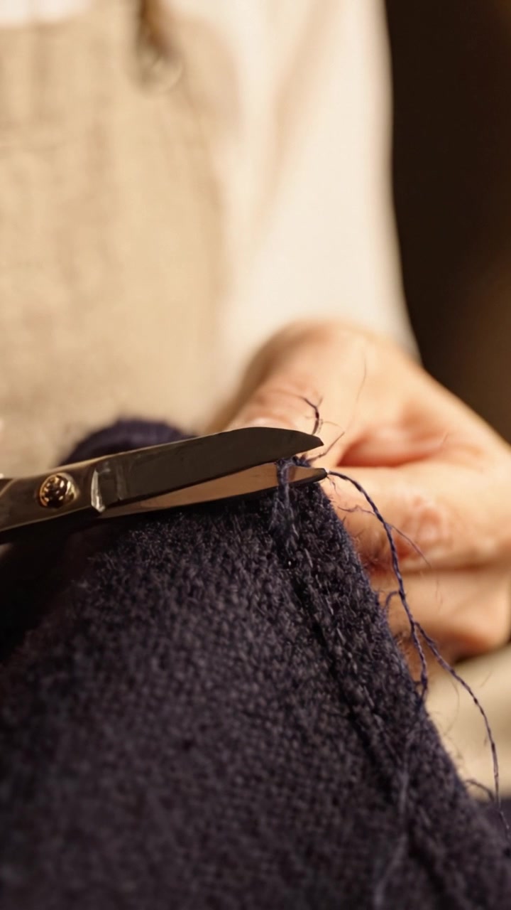 Artisan Carefully Mending Fabric with Needle and Thread in Close-Up, Showcasing Skillful Handwork and Attention to Detail for Textile Repair and Craftsmanship