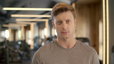 portrait of handsome bodybuilder at gym. sportsman standing in fitness center