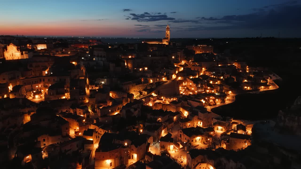 Matera, Italy. Iconic Sassi district with historic buildings from the air. Majestic nighttime aerial