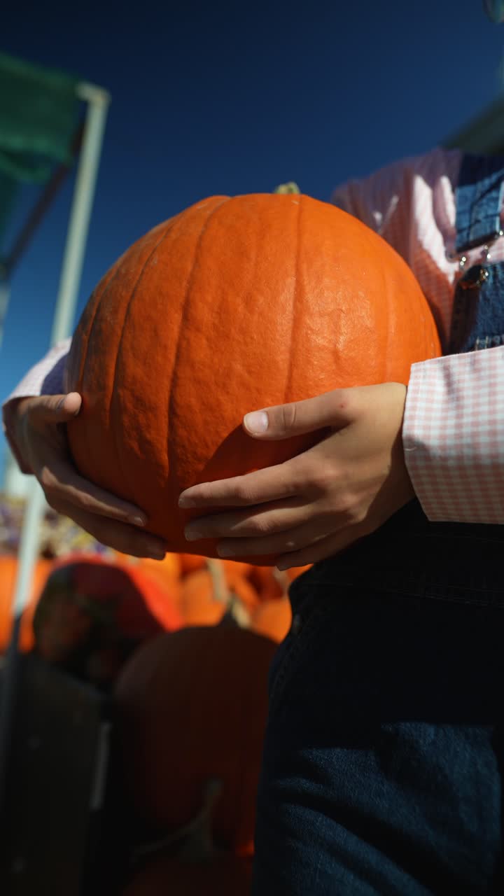 persona que sostiene una calabaza grande