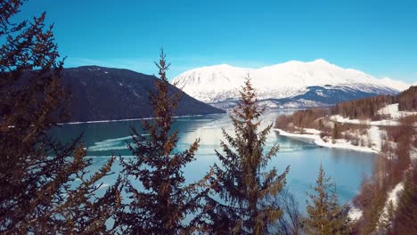 4k drone video of snow covered lakeside mountains in alaska during winter