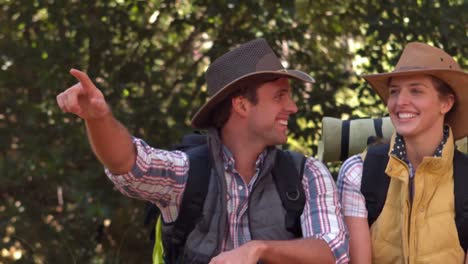 Smiling-couple-pointing-away-on-a-hike-