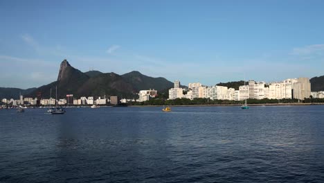 wide panorama view of rio de janeiro at sunrise with the corcovado mountain in the background and pleasure boats scattered and passing in the guanabara bay in front seen from the urca neighbourhood