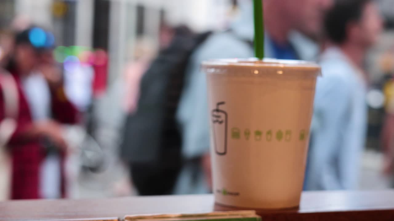 Hareketli bir Londra sokağında bir içecek bardağı