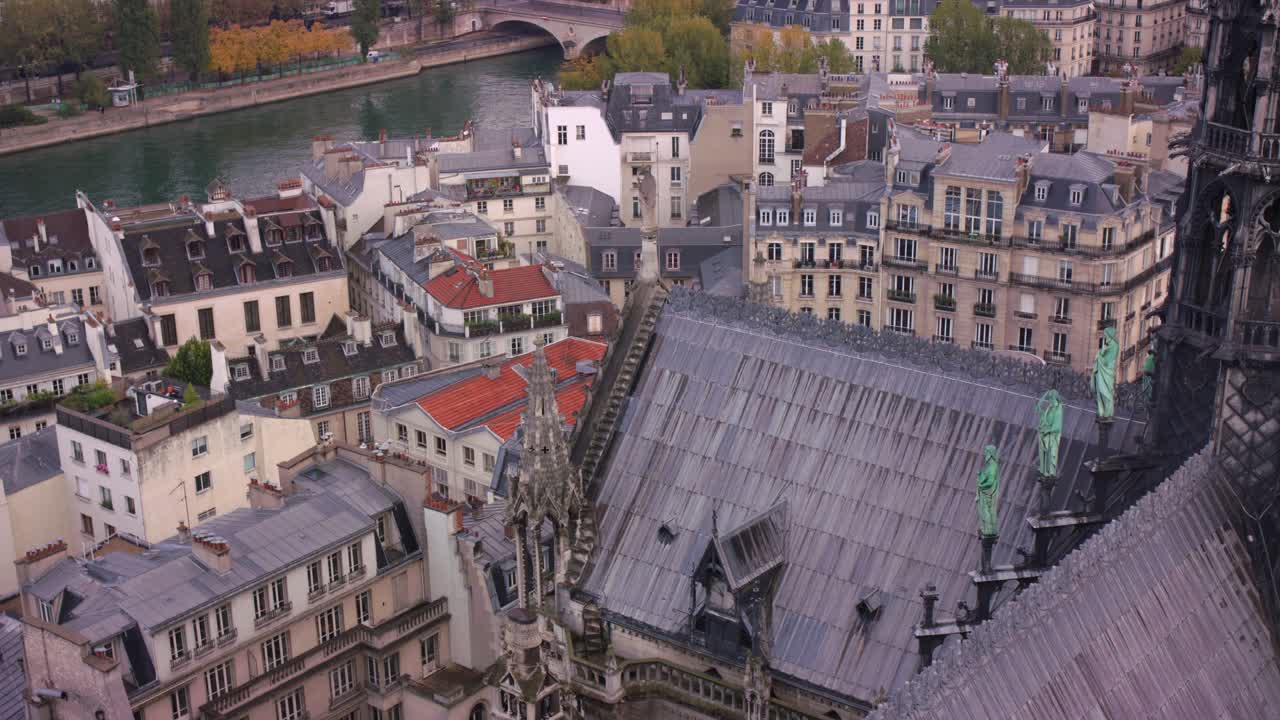 Breathtaking aerial view of Notre-Dame Cathedral with its historic roof, surrounded by classic Parisian rooftops along the Seine River. The beautiful cityscape captures the charm of Paris