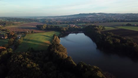 Antena-En-Movimiento-Hacia-Adelante-Sobre-El-Embalse-Del-Lago-Hacia-La-Campiña-Británica---Puente-Del-Lago