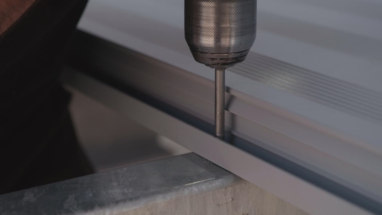 un tornillo se enrosca en la estructura metálica de una terraza utilizando un destornillador inalámbrico