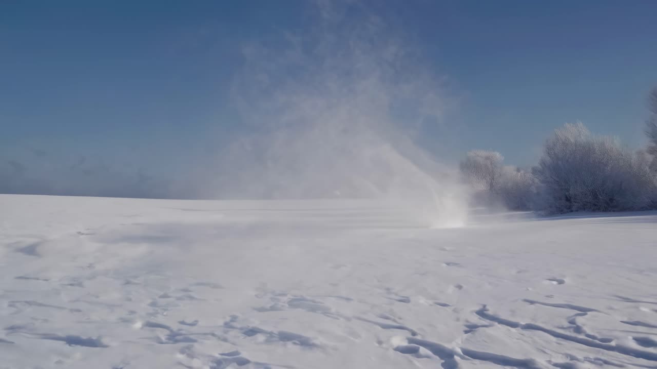 Wide-angle video shot of a vast snow-covered landscape, capturing footprints in the snow