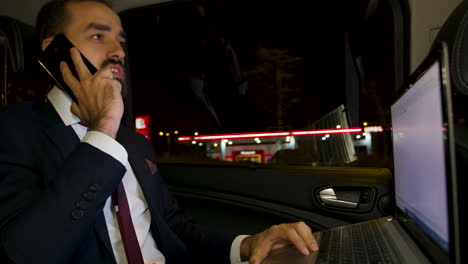 businessman yelling during a phone call sitting in the back seat of his limousine