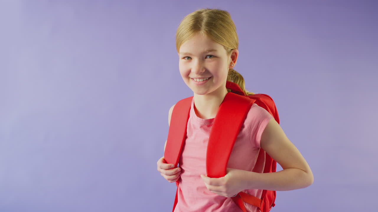 fotografía de estudio de una niña con mochila yendo a la escuela sobre un fondo púrpura