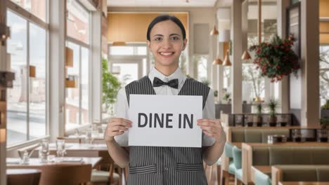 happy indian woman waiter holding dine in banner