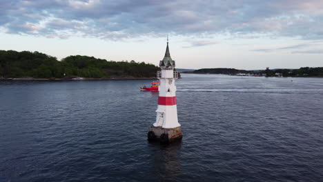 Orbiting-Aerial-shot-of-Kavringen-Lighthouse,-Oslo-at-Golden-Hour-Sunset