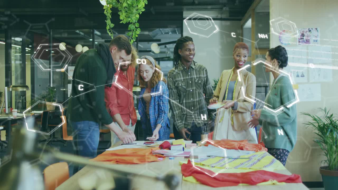 Design team tapping tablet, activating AR overlay and examining swatches for smart textile design