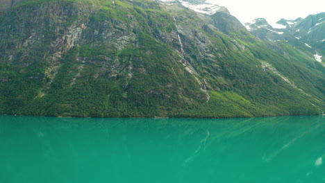 montaña rocosa cubierta de musgo en la orilla del río en stryn, noruega