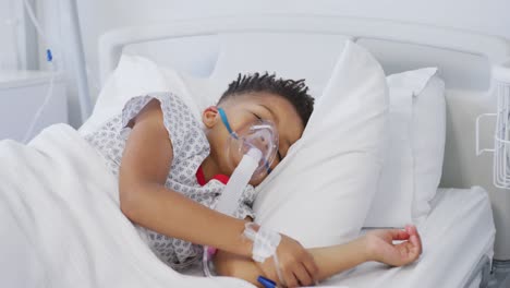 African-american-boy-patient-wearing-oxygen-mask,-lying-in-bed-at-hospital