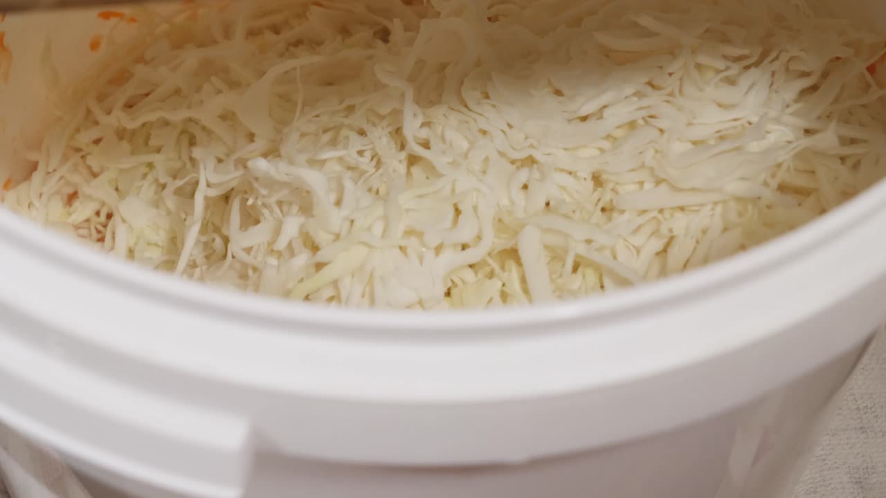 Grate cabbage in the bucket for sauerkraut