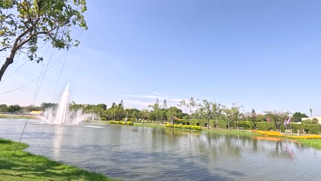 una escena pacífica en un parque con una fuente, flores y un sendero en bangkok.